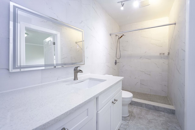 bathroom featuring a tile shower, toilet, and vanity