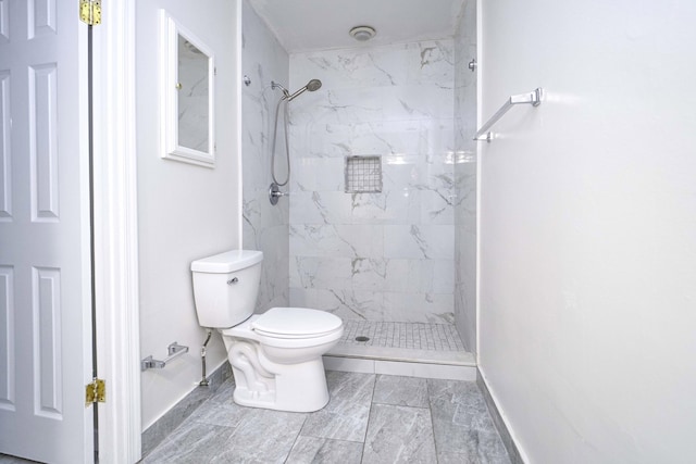 bathroom featuring toilet and a tile shower