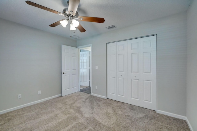 unfurnished bedroom featuring light carpet, a closet, and ceiling fan