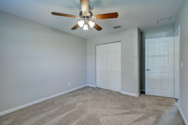 unfurnished bedroom with ceiling fan, light colored carpet, and a closet