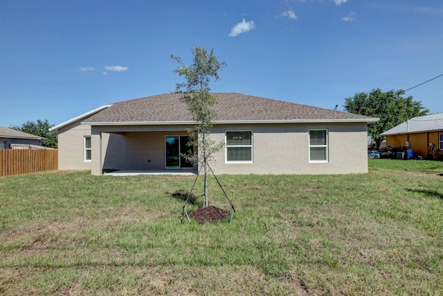 rear view of property featuring a lawn and a patio area