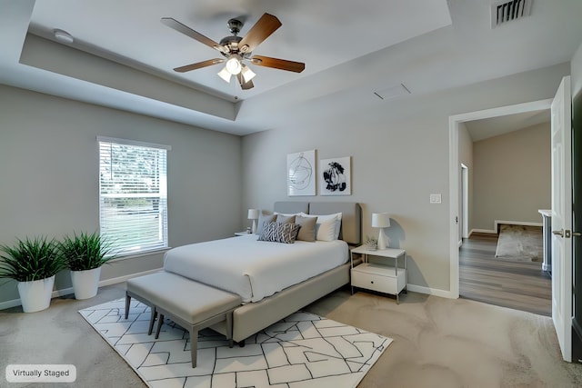 bedroom featuring a raised ceiling and ceiling fan