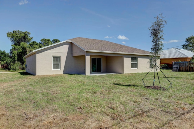 rear view of property featuring a yard