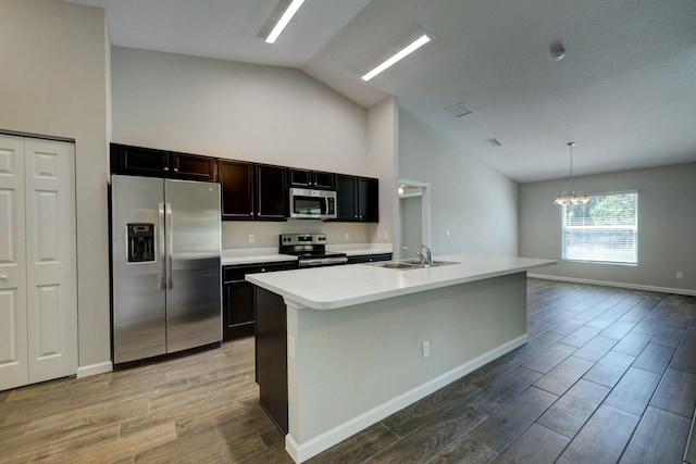 kitchen featuring hanging light fixtures, appliances with stainless steel finishes, a kitchen island with sink, and sink