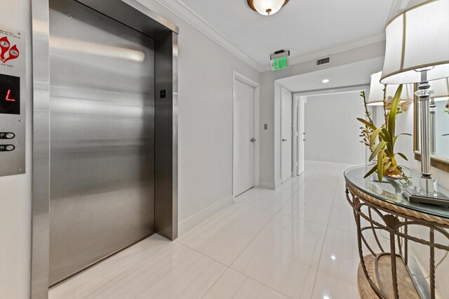 hall featuring light tile patterned flooring, elevator, and ornamental molding