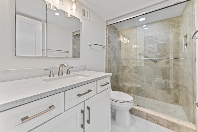 bathroom featuring a shower with door, vanity, and toilet