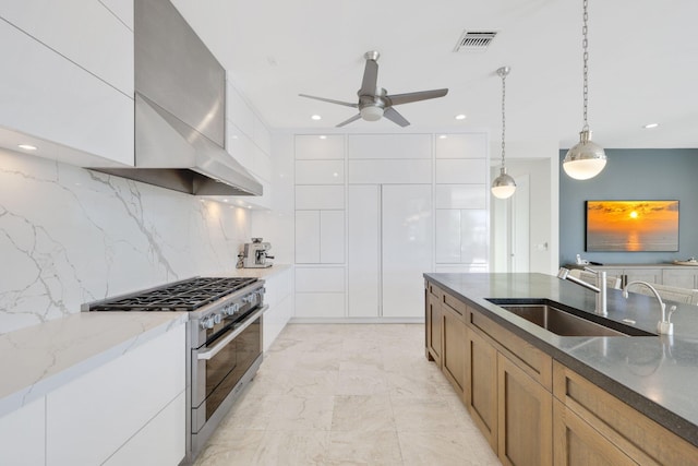 kitchen with white cabinetry, sink, and high end stainless steel range