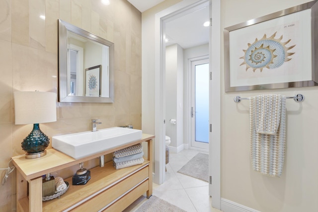 bathroom featuring toilet, sink, tile walls, tile patterned flooring, and decorative backsplash