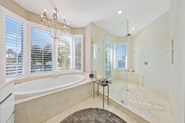 bathroom with a wealth of natural light, shower with separate bathtub, and a chandelier