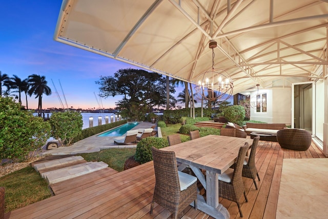 deck at dusk featuring a water view and outdoor lounge area