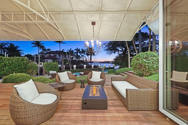 deck at dusk with an outdoor living space with a fire pit