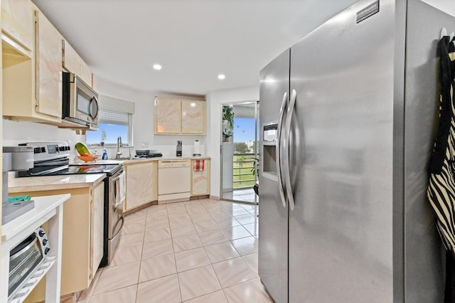 kitchen with stainless steel appliances, a sink, recessed lighting, light brown cabinets, and light countertops