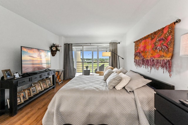 bedroom with access to outside and wood finished floors