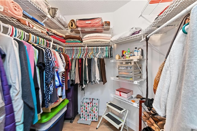 walk in closet with wood finished floors