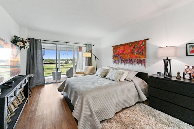 bedroom featuring wood-type flooring and access to exterior