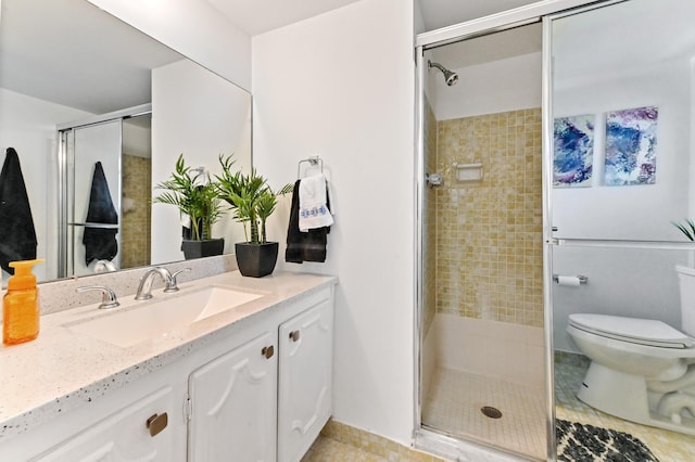 full bath featuring toilet, vanity, tile patterned floors, and a stall shower