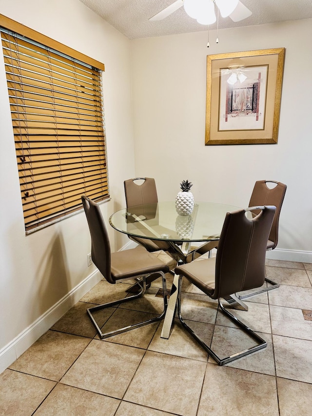 tiled dining room featuring a textured ceiling and ceiling fan