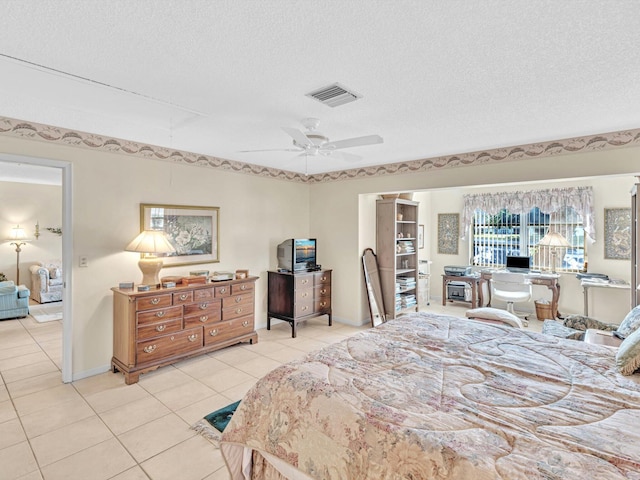 bedroom featuring a textured ceiling, light tile patterned floors, and ceiling fan