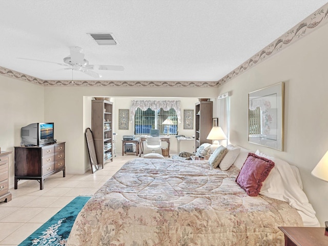 tiled bedroom with a textured ceiling and ceiling fan