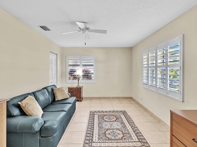 tiled living room featuring ceiling fan and a textured ceiling