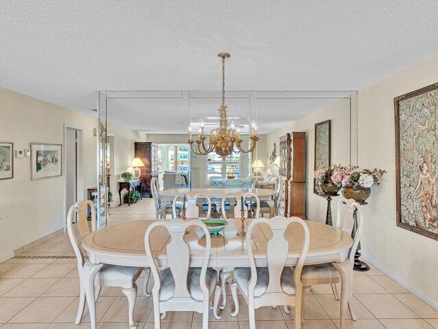 tiled dining space with a textured ceiling and an inviting chandelier