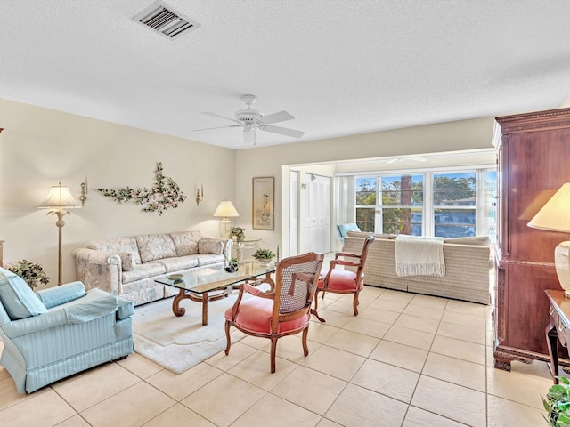 living room featuring ceiling fan, a textured ceiling, and light tile patterned flooring