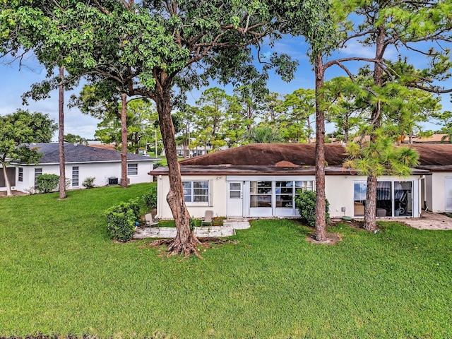 rear view of house featuring a lawn