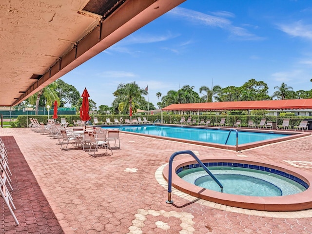 view of swimming pool with a patio area and a hot tub