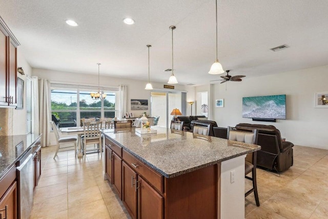 kitchen featuring a kitchen breakfast bar, pendant lighting, dark stone counters, and a kitchen island