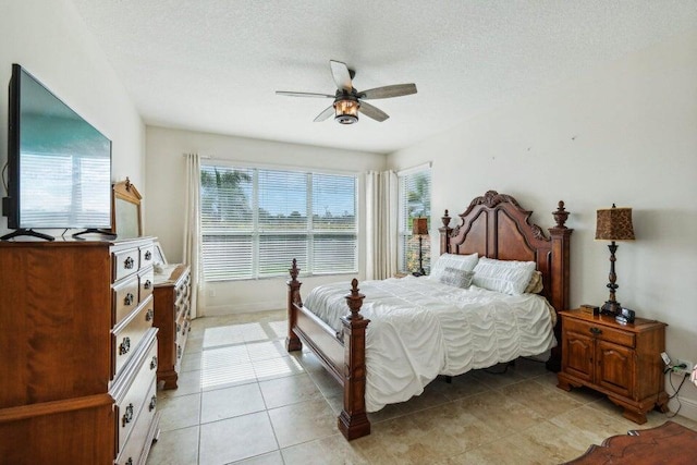 tiled bedroom featuring a textured ceiling and ceiling fan