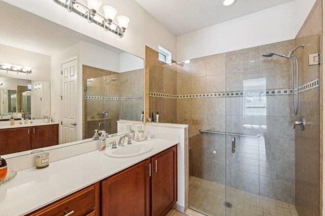 bathroom with a shower with shower door and vanity