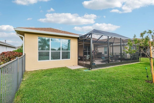 rear view of property with a patio area, a lanai, and a yard