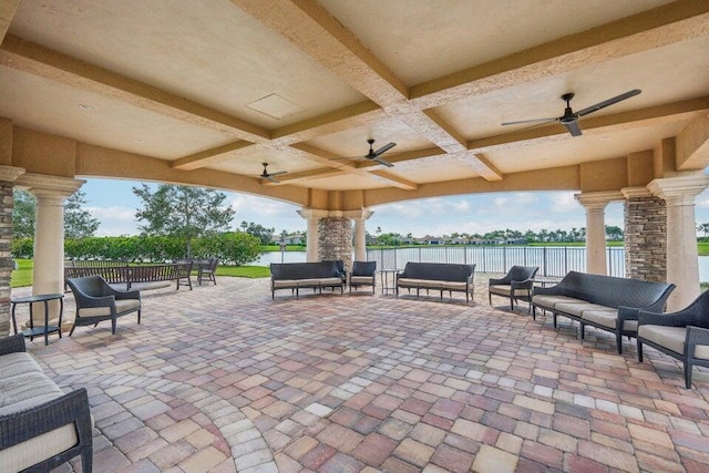 view of patio with an outdoor living space, ceiling fan, and a water view