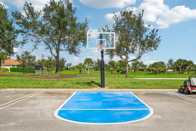 view of sport court with a lawn