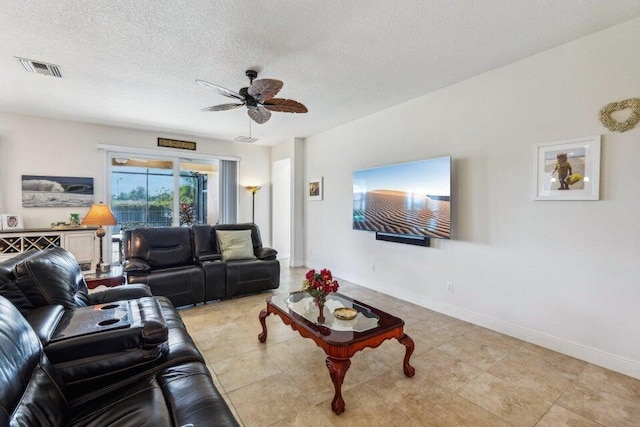 living room featuring ceiling fan and a textured ceiling