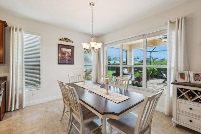 dining space featuring ceiling fan with notable chandelier