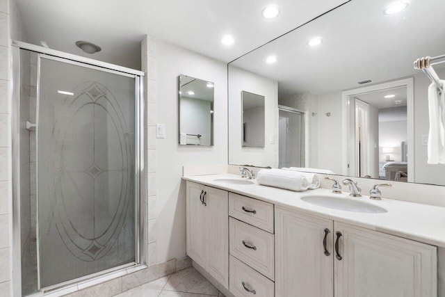 bathroom featuring a shower with door, vanity, and tile patterned flooring