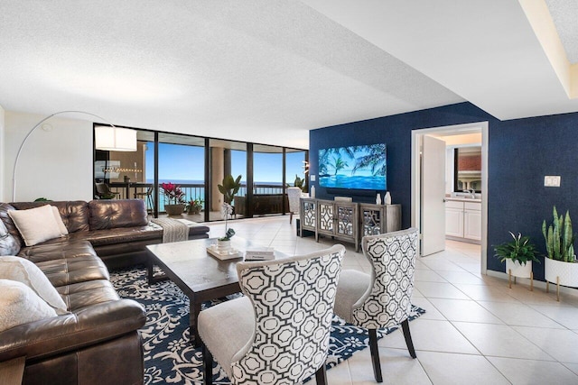 living room with floor to ceiling windows, a textured ceiling, and light tile patterned floors