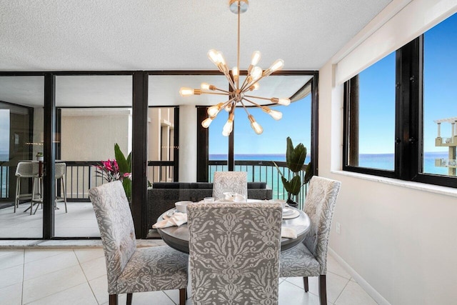 tiled dining room with a chandelier, a textured ceiling, a wall of windows, and a water view