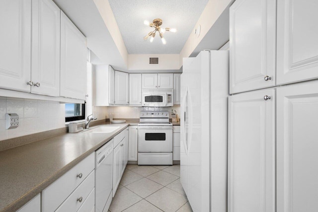 kitchen featuring white appliances, white cabinets, a textured ceiling, sink, and light tile patterned floors