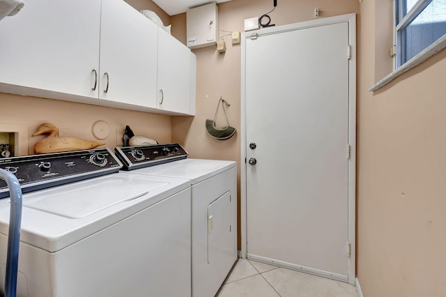 washroom featuring cabinets, independent washer and dryer, and light tile patterned floors