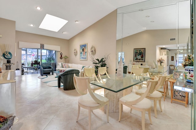 dining area with light tile patterned floors and lofted ceiling with skylight