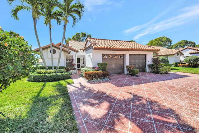 mediterranean / spanish-style house featuring a garage and a front lawn