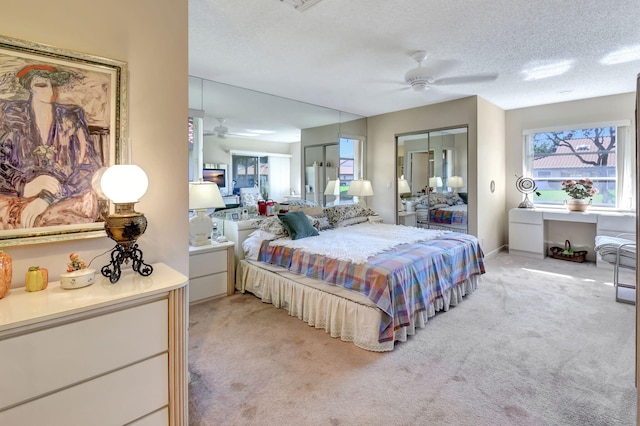 carpeted bedroom with a textured ceiling, ceiling fan, and a closet