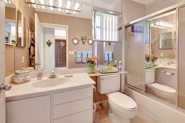 full bathroom featuring vanity, combined bath / shower with glass door, and toilet