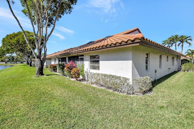 view of side of property with a water view and a lawn