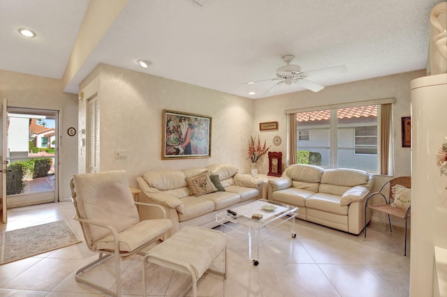 tiled living room with a textured ceiling and ceiling fan