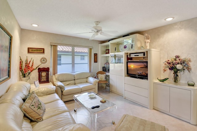 tiled living room with ceiling fan and a textured ceiling