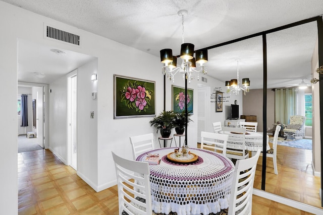 dining room with a textured ceiling and a notable chandelier