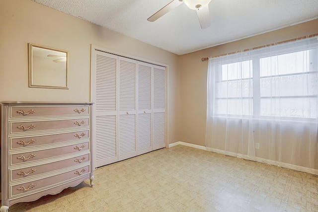 unfurnished bedroom with a textured ceiling, a closet, and ceiling fan